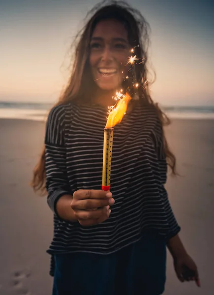 Mujer sosteniendo fuegos artificiales en la playa —  Fotos de Stock