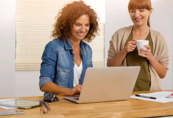 Бізнес-леді працюють разом на ноутбуці в офісі — стокове фото