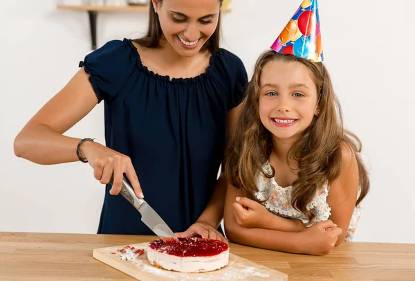 Mãe e filha cortando bolo de aniversário — Fotografia de Stock