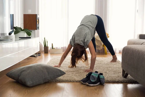 Kvinde laver yoga motion derhjemme - Stock-foto