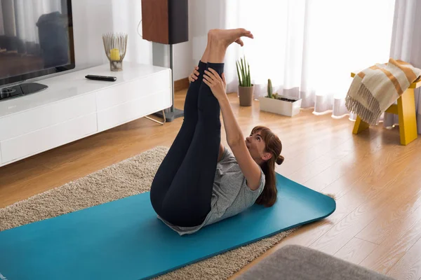 Mujer haciendo ejercicio de yoga en casa —  Fotos de Stock