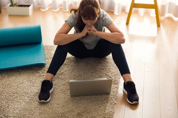 Kvinna i sportskläder använder laptop — Stockfoto