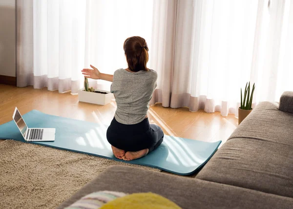 Kvinde laver yoga motion derhjemme - Stock-foto