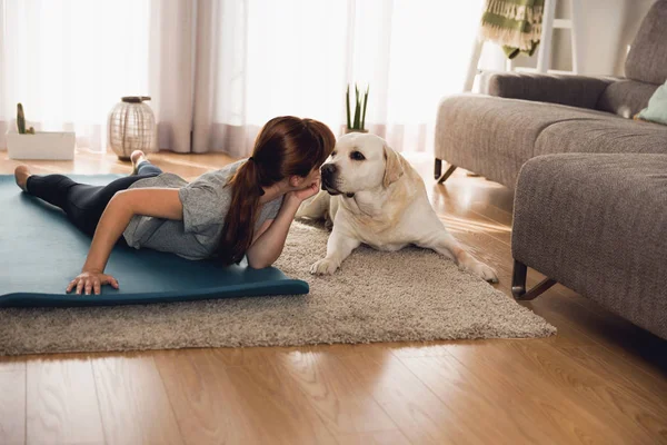 Mujer haciendo ejercicio de yoga con perro —  Fotos de Stock