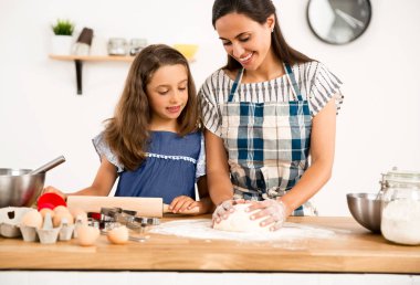 mother and daughter  learning to make a cake  clipart