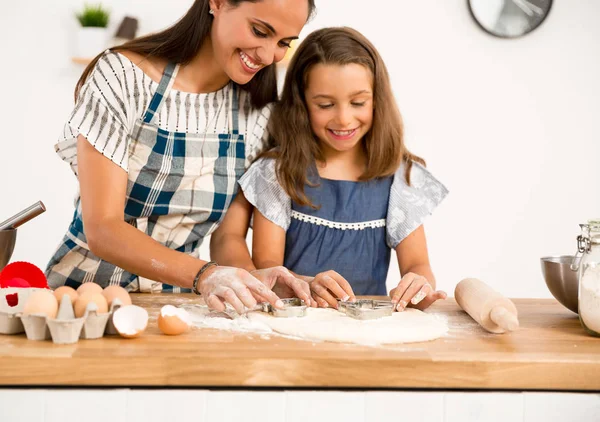 mother and daughter  learning to make a cake