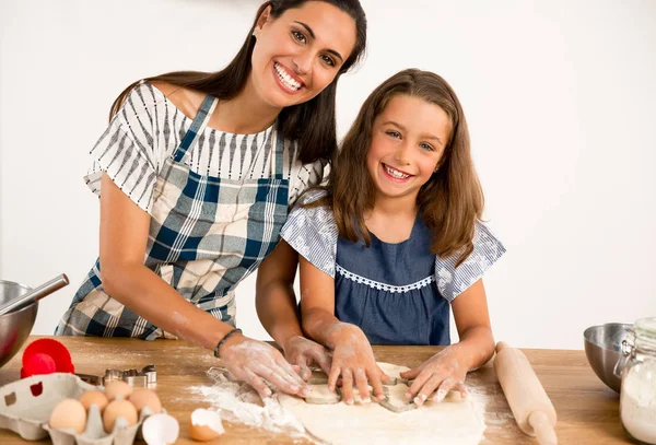 mother and daughter  learning to make a cake