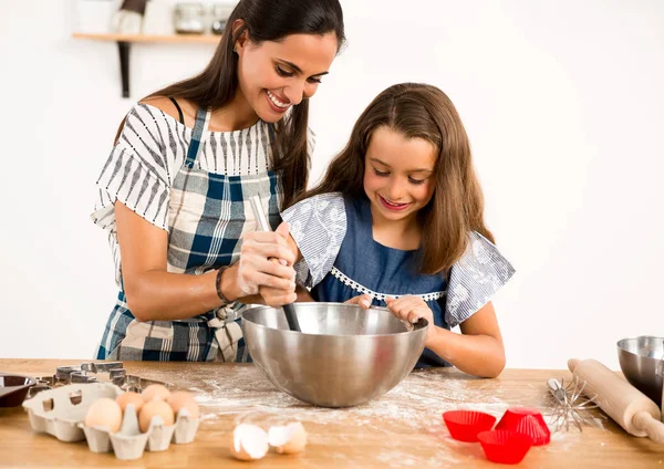 mother and daughter  learning to make a cake