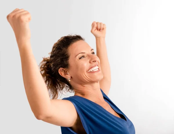 Kvinna med armar upp uttrycker seger — Stockfoto