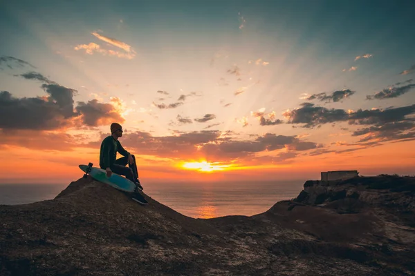 Homme avec planche à roulettes au coucher du soleil — Photo
