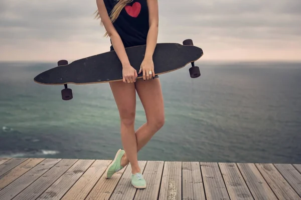 Mladá žena pózuje s skateboard — Stock fotografie