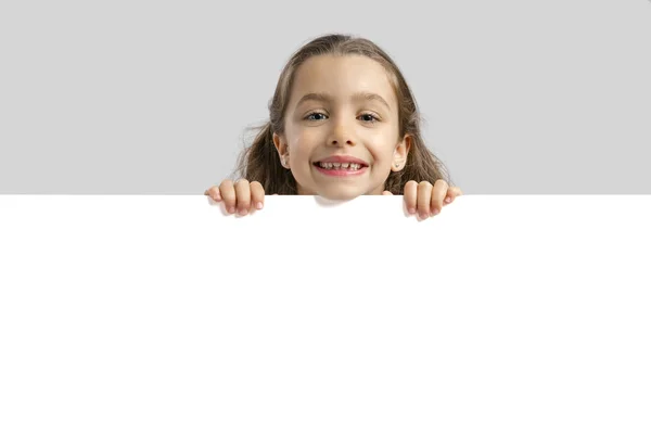 Menina bonito segurando placa em branco — Fotografia de Stock