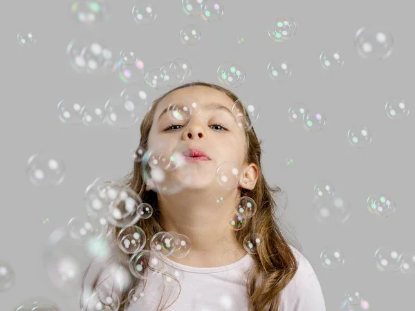 Девушка играет с мыльными пузырями — стоковое фото