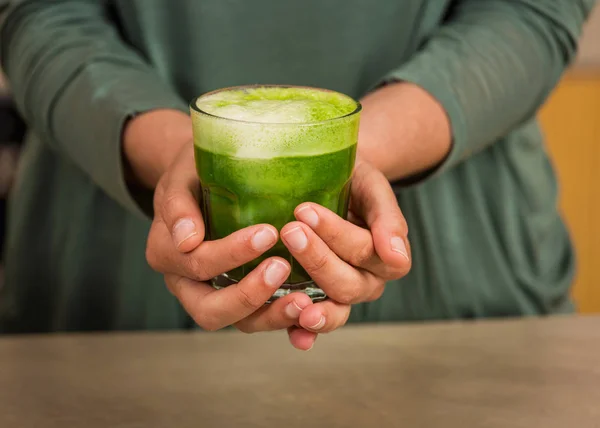 Женщина держит стакан зеленого сока — стоковое фото