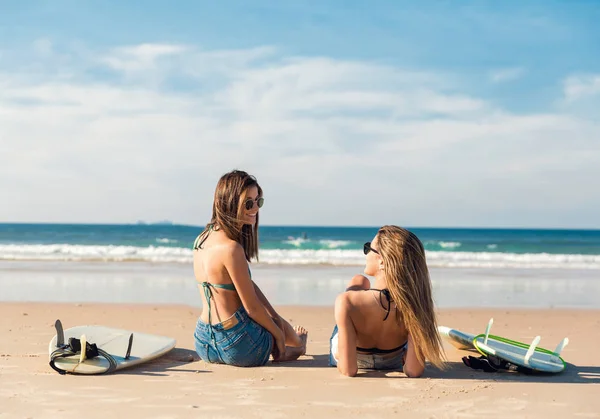 Två Vackra Unga Kvinnor Sitter Sandstrand Med Surfbrädor Och Pratar — Stockfoto