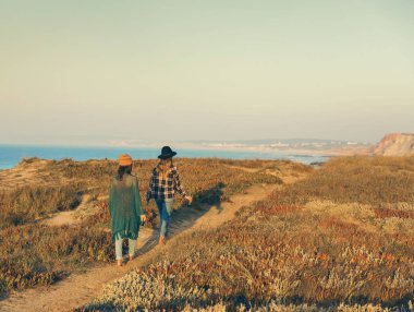 Kıyı şeridi üzerinde günbatımında yürüyüş en iyi iki arkadaş