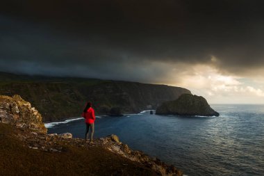 Cliff üzerinde duran ve deniz, Azores, Portekiz için arayan kadın