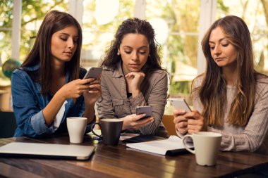 Akıllı telefonlar kahve yudumlarken kullanarak kız grubu