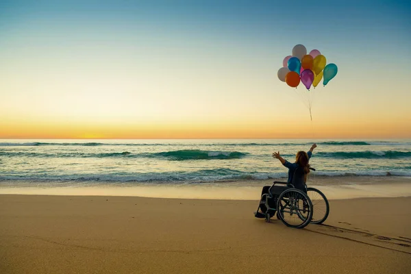 Handicapped Woman Wheelchair Colored Balloons Rising Hands Beach — Stock Photo, Image