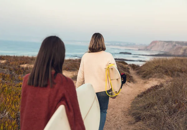 Οπίσθια Όψη Των Δύο Θηλυκά Surfers Περπάτημα Κοντά Ακτογραμμή Ιστιοσανίδες — Φωτογραφία Αρχείου