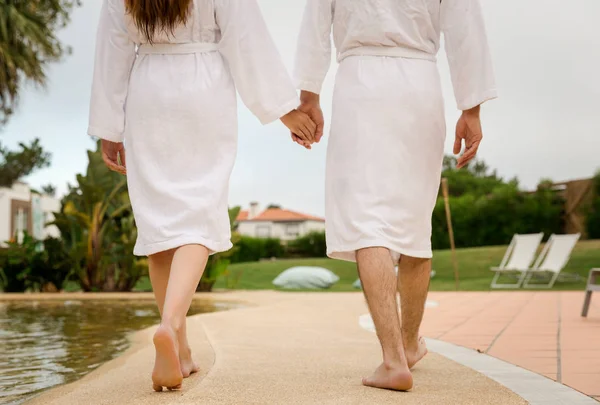 上の手を歩いてバスローブで若いカップルの背面図 — ストック写真