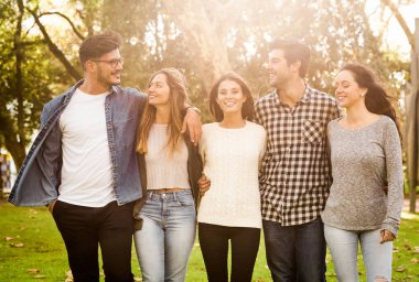 Bir grup öğrenci parkta birlikte yürüyor.