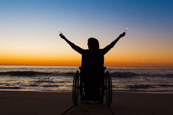 Handicapped woman holding fire sparklers — Stock Photo, Image