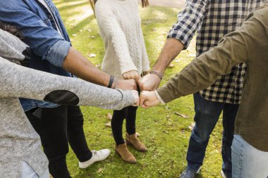Bir grup arkadaşın yumruklarını birleştirirken yüksek açı çekimi.