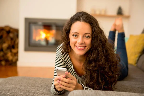 Hermosa Mujer Usando Teléfono Celular Casa Calor Una Chimenea — Foto de Stock