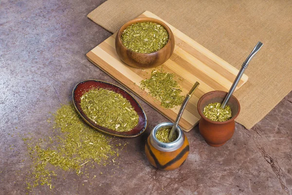 Yerba mate em calabash, em porongo e em tigelas em fundo de pedra — Fotografia de Stock