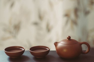 Çin kil çay fincanları ve ahşap masada kil çay demliği.