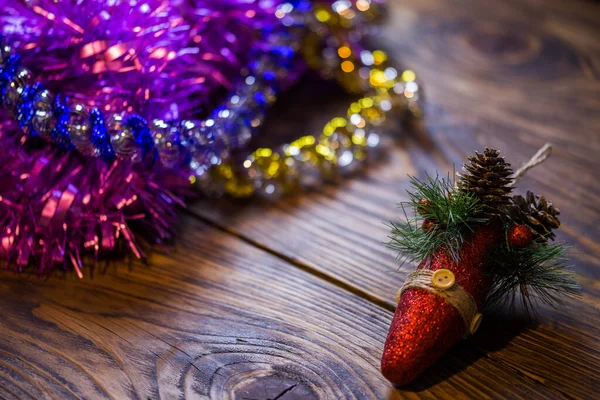 En jul träd leksak och lila tinsel på brunt trä bakgrund — Stockfoto