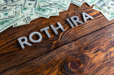 Kelimeler Roth Ira biz dolar banknotlarıyla metal harflerle ahşap yüzeye serildi.