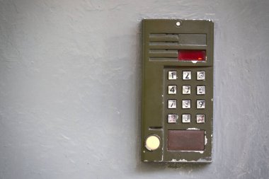 Gri düz yüzeydeki eski dijital kapı telefonu