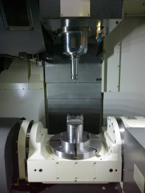 The five-axis Computer Numerical Control CNC machine waiting for stock change clipart