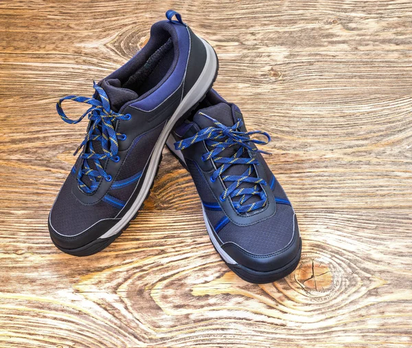 Zapatillas de deporte al aire libre negras en superficie de madera — Foto de Stock