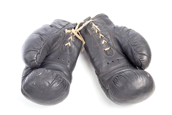 Old black leather boxing gloves isolated on white background with shadows lying on flat surface — Stock Photo, Image