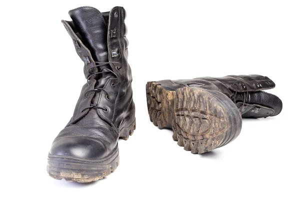 Usado botas negras militares sucias y polvorientas aisladas en la espalda blanca — Foto de Stock