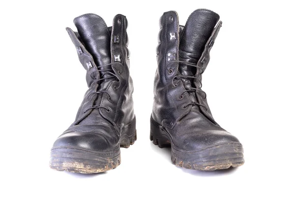 Usado botas negras militares sucias y polvorientas aisladas en la espalda blanca — Foto de Stock