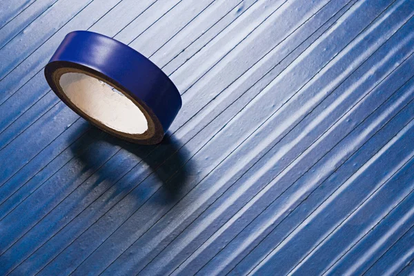 one roll of old blue pvc duct tape on ti\'s self flat background