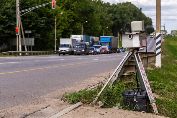 Dispositivo de cámara de velocidad móvil en trípode trabajando en carretera diurna de verano con tráfico borroso en segundo plano — Foto de Stock