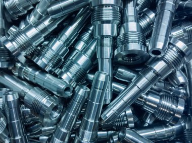 Parlak çelik parçalar arka plan, modern ince cnc dönüm sonra uzun çelik çubuklar apile