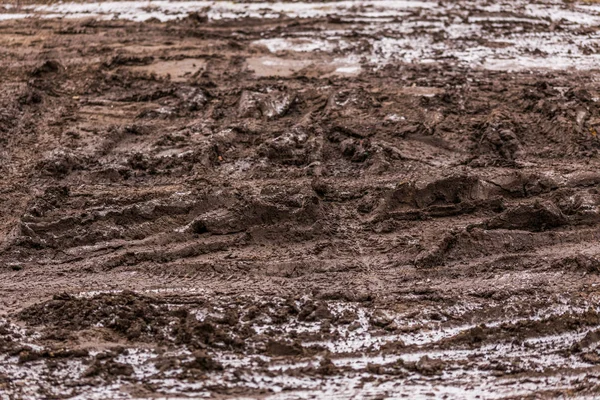 Smutsig lera väg bakgrund på vintern med selektivt fokus och oskärpa — Stockfoto