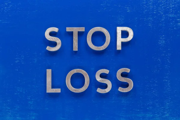 The phrase stop loss laid on blue painted board with thick silver metal aphabet characters. — Stock Photo, Image