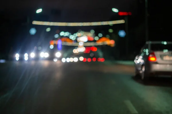 Defocked beeld van de nacht straat autoverkeer - uitzicht vanaf de weg. Kleurrijke nacht leven achtergrond. — Stockfoto