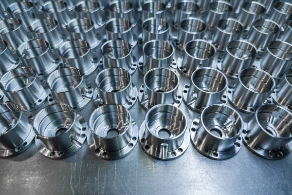 Um lote de metal brilhante cnc produção de peças aeroespaciais - close-up com foco seletivo para fundo industrial — Fotografia de Stock