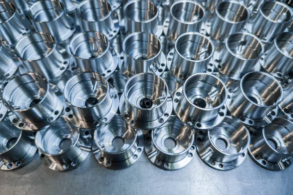 Um lote de peças aeroespaciais de alumínio brilhante feitas com máquina cnc close-up com borrão de fundo, pano de fundo industrial — Fotografia de Stock