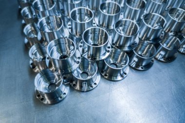 Çelik yüzeydeki cnc makinesinden sonra seçici odaklı, endüstriyel arka planda parlak metal parçacıkları