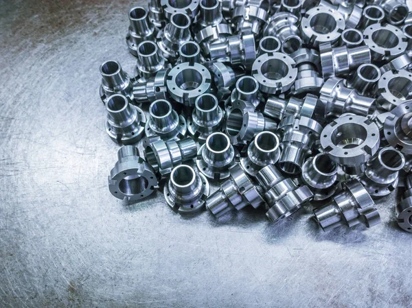 A pile of shiny steel parts after cnc turning and milling operations on steel sheet - close-up with selective focus. — 스톡 사진