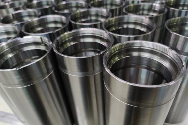 a close-up shot of shiny steel aerospace cnc turned tubes in a batch with selective focus and background blur